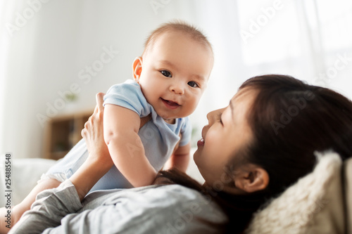 family and motherhood concept - happy young asian mother with little baby son at home