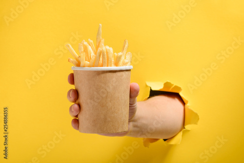 Hand giving French fries photo