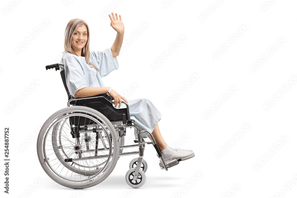 Smiling female patient in a wheelchair waving at the camera Smiling female patient in a wheelchair waving at the camera