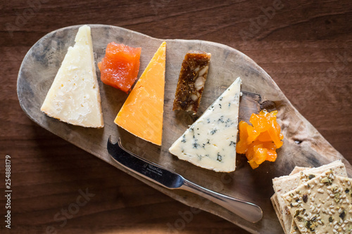 Принти на полотні stilton, cheddar and red Leicester cheese slices on wooden board