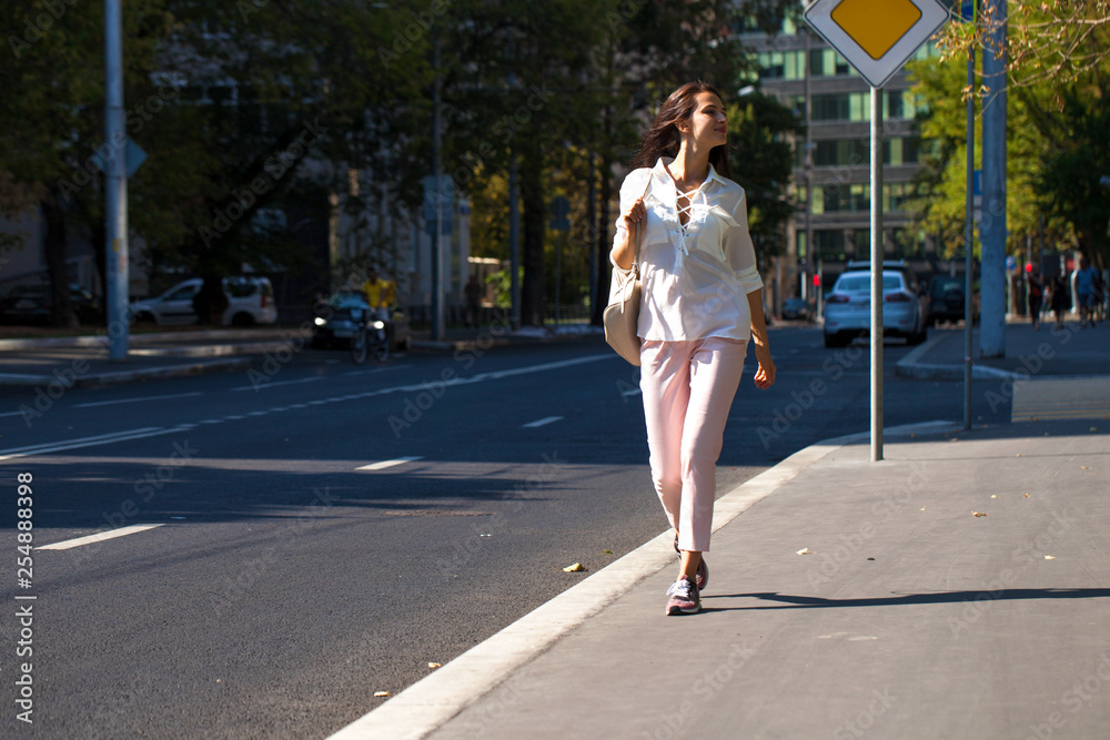 Young beautiful brunette woman walking on the street Young beautiful brunette woman walking on the street