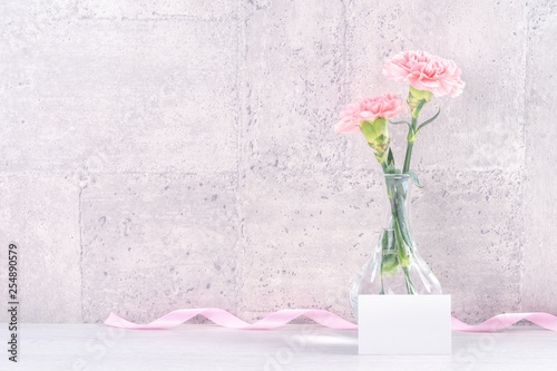Fototapeta Naklejka Na Ścianę i Meble -  Mothers day handmade giftbox surprise wishes photography - Beautiful blooming carnations with pink ribbon box isolated on gray wallpaper design, close up, copy space, mock up