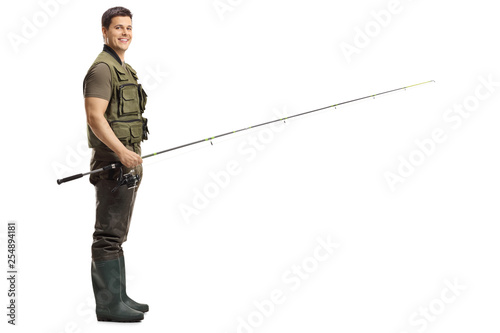 Young male fisherman with a fishing rod looking at the camera