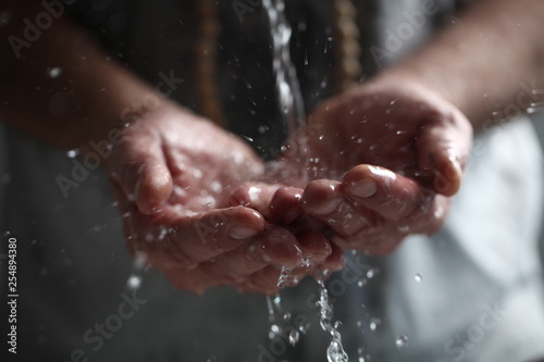 Muslim man washes his hands before prayer ritual cleansing. photo