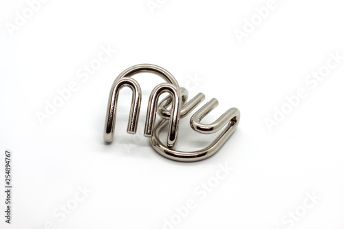 Modern metal cast puzzle Devil's claws isolated on white background