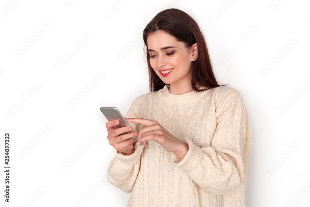Young woman studio standing isolated on white checking media on smartphone joyful Young woman studio standing isolated on white checking media on smartphone joyful