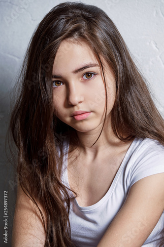 Closeup portrait teenager girl. Girl brunette asian. Vertical portrait fashion. Perfect young model interracial appearance. young girl looks confident, defiant.