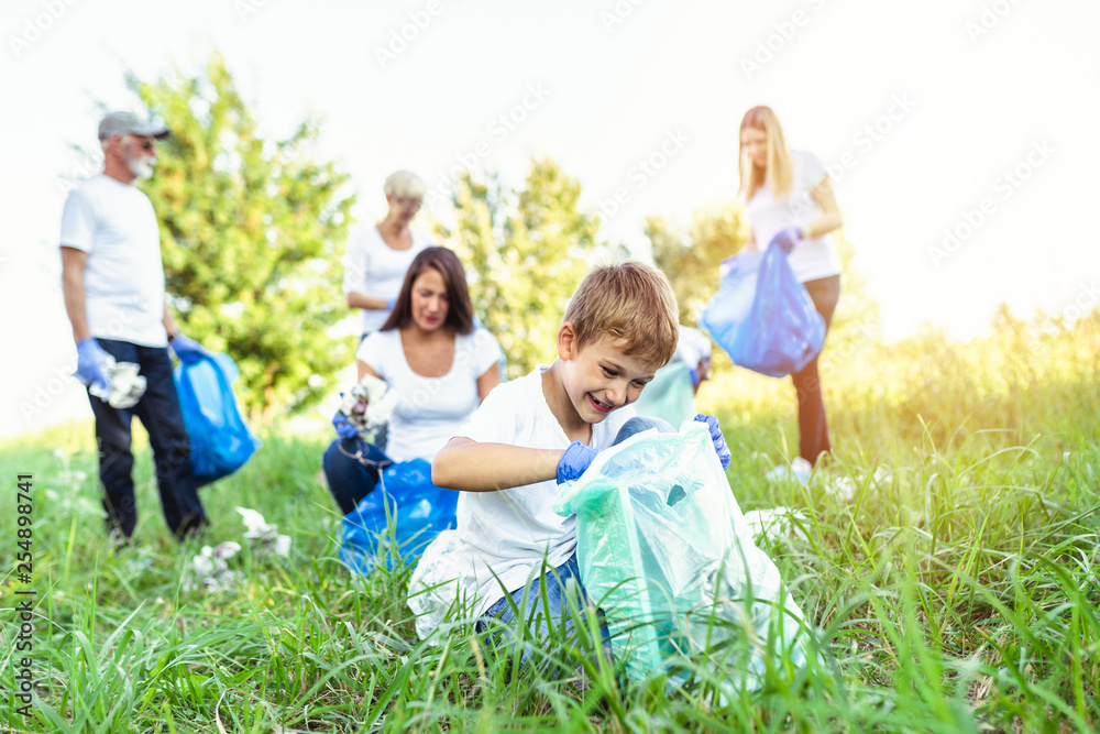 Fototapeta premium Volunteers with garbage bags cleaning up garbage outdoors - ecology concept.