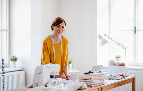 Foto Young creative woman in a studio, startup of small tailoring business
