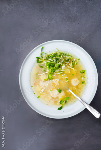 cauliflower soup with chicken fillet in a bowl, with herbs, greens on concrete background Top view with copy space.