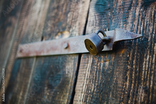 Old vintage padlock on wooden doors. Shallow focus - Rusty.