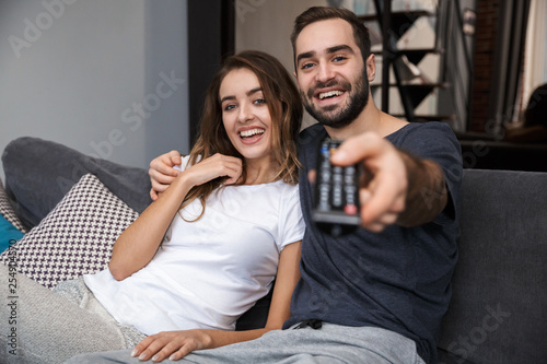 Cheerful young couple relaxing on couch at home