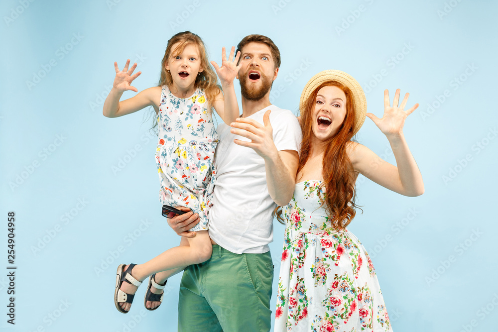 Happy surprised parent with daughter at studio isolated on blue background. Travel, vacation, parenthood, togetherness, tourism concept. Happy surprised parent with daughter at studio isolated on blue background. Travel, vacation, parenthood, togetherness, tourism concept.