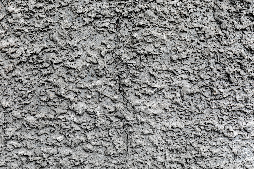 Grey concrete wall with rough surface and big crack Grey concrete wall with rough surface and big crack