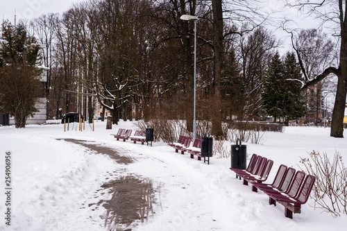 Red metal park benches covered in snow isolated  © Alvis