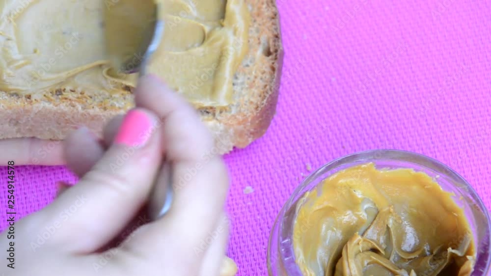 Vídeo do Stock girl making a sandwich. spooning peanut butter out of a