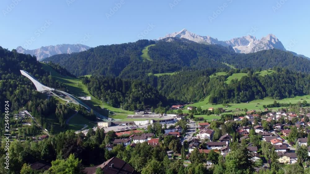 Drone flies over Garmisch-Partenkirchen and opens up a beautiful view of the olympia chanze and zugspitze in the background Drone flies over Garmisch-Partenkirchen and opens up a beautiful view of the olympia chanze and zugspitze in the background