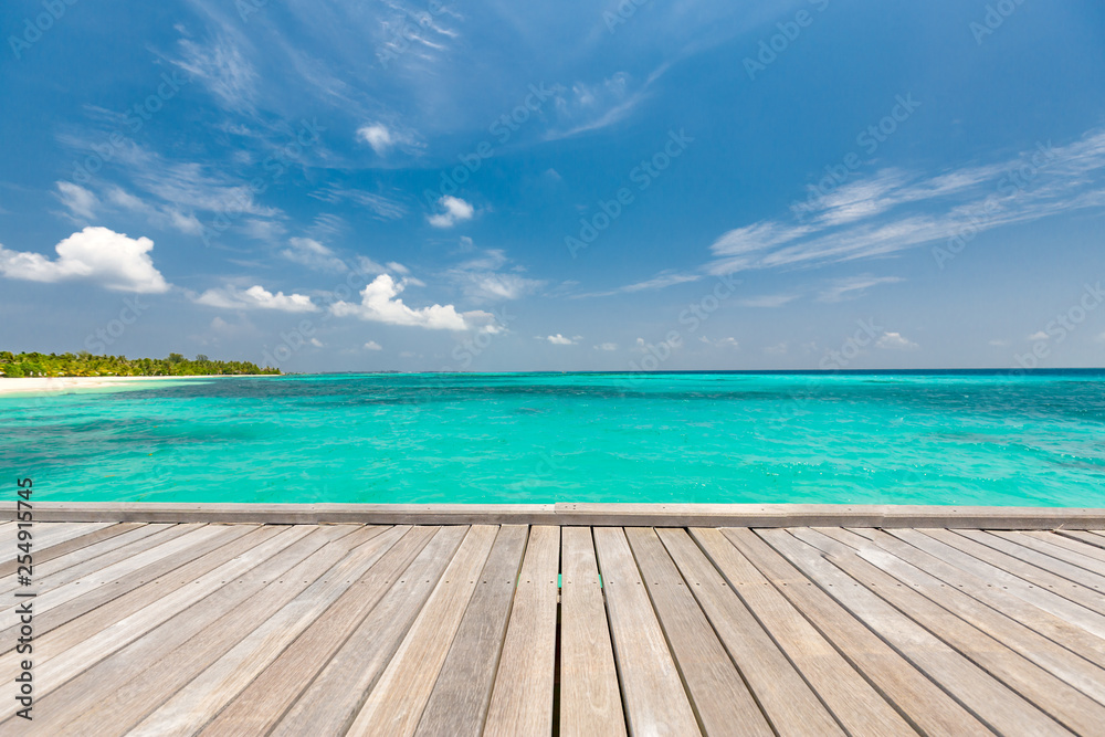Empty wooden planks with blur beach on background, can be used for product placement, palm leaves on foreground