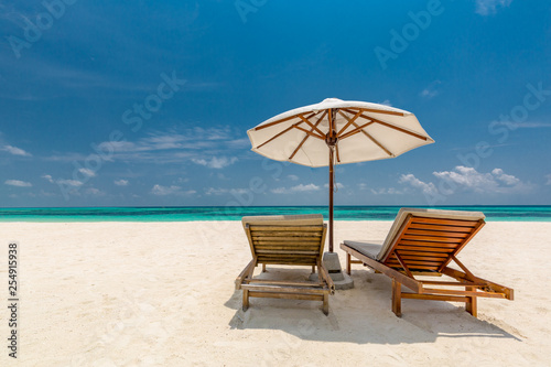 Beautiful Maldives island beach landscape. Luxury resort with chairs and umbrella for summer vacation and holiday background. Exotic tropical beach concept © icemanphotos