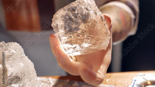 Barman is making brand ice for the cocktail at bar