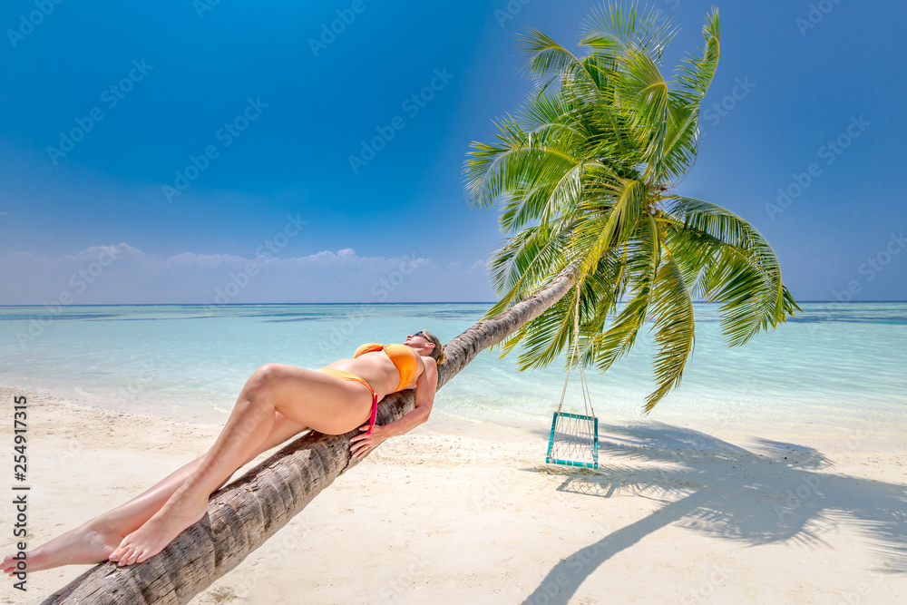 Woman in bikini on tropical beach. Luxury lifestyle, travel and vacation background