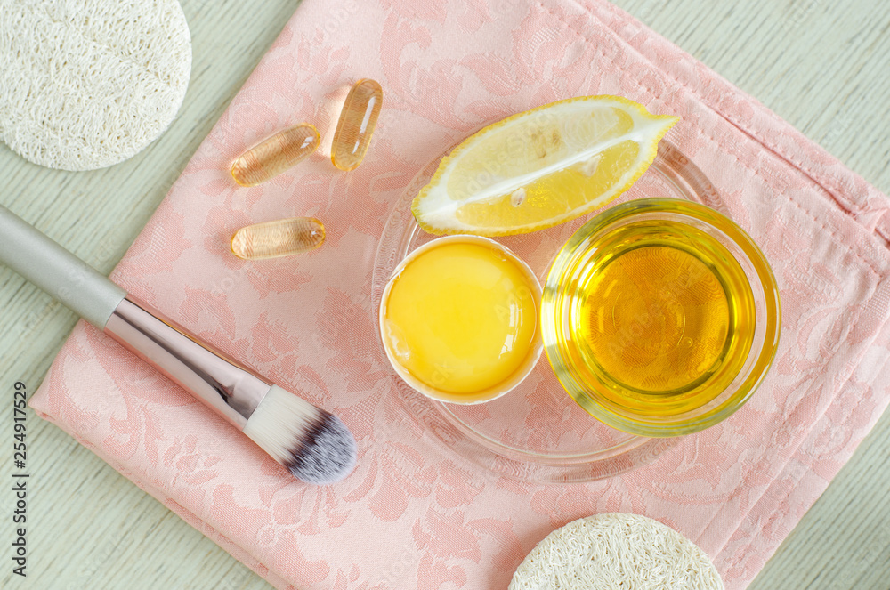 Olive oil, raw egg, lemon and vitamin E softgels - ingredients for preparing diy face and hair masks, scrubs and moisturizers. Homemade beauty treatments recipe. Top view, copy space Olive oil, raw egg, lemon and vitamin E softgels - ingredients for preparing diy face and hair masks, scrubs and moisturizers. Homemade beauty treatments recipe. Top view, copy space