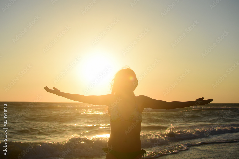 Woman on the beach relax at sunset. Summer vacations concept, sexy woman enjoy at sunset