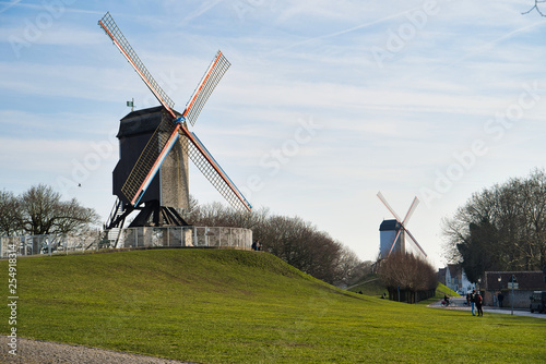 BRUGES, BELGIUM - FEBRUARY 17, 2019: 18th century old mill of Saint Janus, on a green grassy hill photo