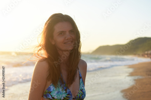 Woman on the beach relax at sunset. Summer vacations concept, sexy woman enjoy at sunset