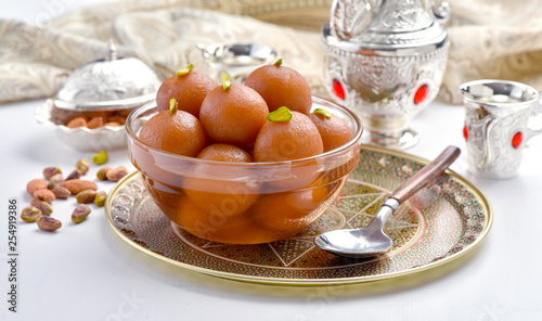 Gulab Jamun or Gulab Jaman in crystal bowl with arabian crockery photo