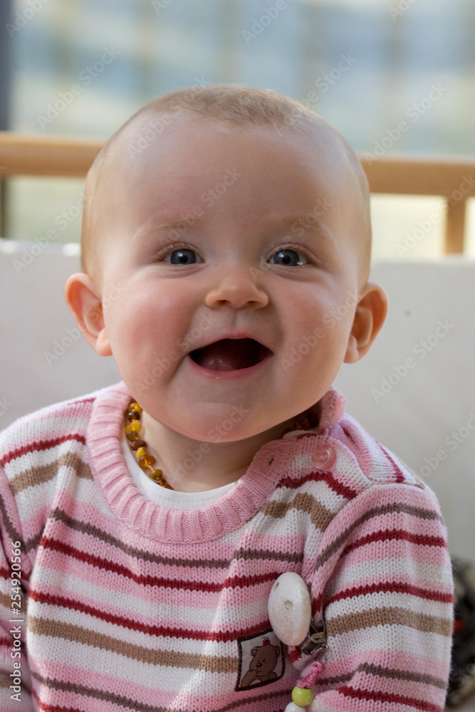Fröhliches lachendes Mädchen im rosa gestreiften Pullover Fröhliches lachendes Mädchen im rosa gestreiften Pullover