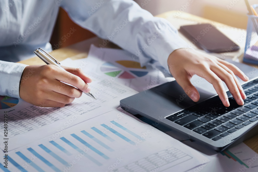 Naklejka premium businesswoman working on desk using laptop for check data of finance in office