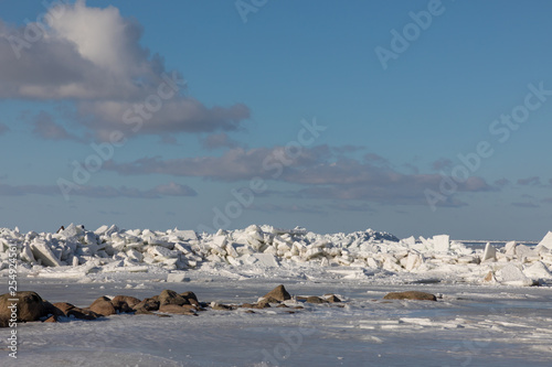 Seaside with frozen and melting ice with rocks