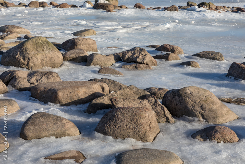 Fototapeta premium Seaside with frozen and melting ice with rocks