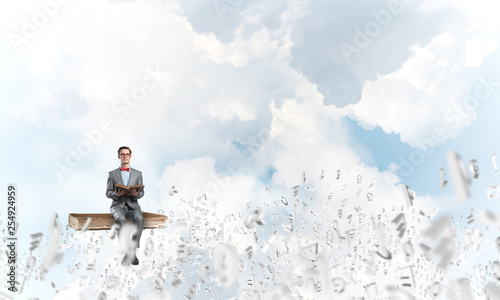Young businessman or student studying the science and symbols fly around
