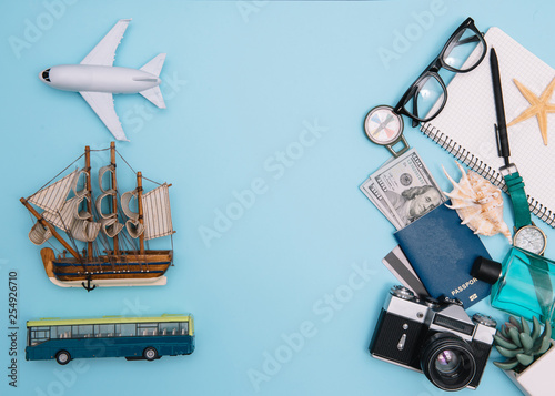 top view travel concept with retro camera films, smartphone, map, passport, compass and Outfit of traveler on blue background with copy space, Tourist essentials, vintage tone effect