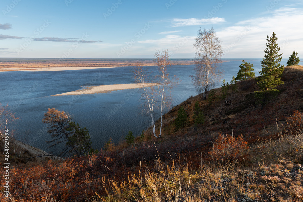 Yakutian landscape with a trees and the great Lena River at gold sunset. Beautiful view from the Tabaginsky cape to the islands Yakutian landscape with a trees and the great Lena River at gold sunset. Beautiful view from the Tabaginsky cape to the islands