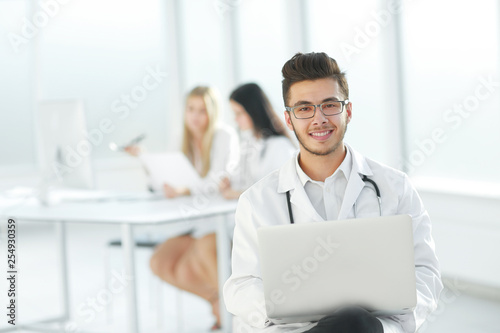 doctor works on a laptop in the hospital room