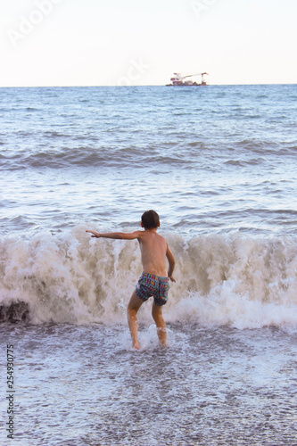 The boy frolics in the big waves