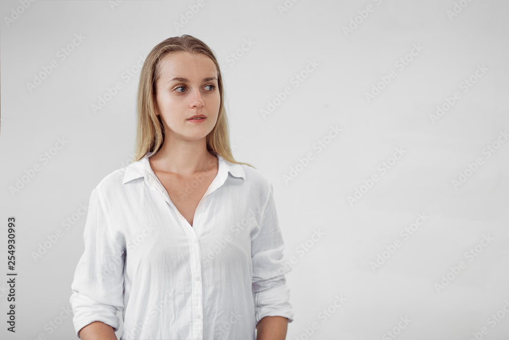 Girl in white shirt on light background looking right, copy space Girl in white shirt on light background looking right, copy space