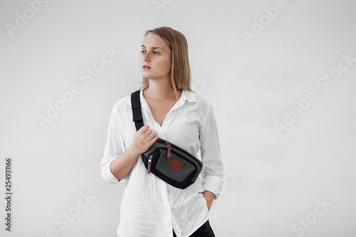 Girl with a Fanny pack on the front of a white wall