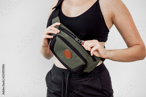 Bilde på lerret Sporty girl with fanny bag on white background