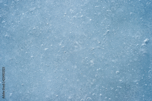 Ice with air bubbles of a blue shade. Textured abstract natural background