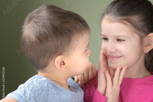 Fotografie White caucasian toddler boy and girl look at each other with love on blurred neutral background