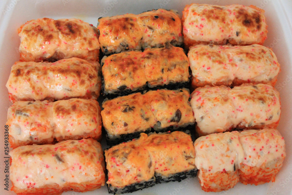 Sushi roll set top view on plate. Baked salmon and eel unagi rolls tasty famous japanese food for lunch or dinner. Asian cuisine menu seafood options, tasty freshly cooked hot sushi close up view Sushi roll set top view on plate. Baked salmon and eel unagi rolls tasty famous japanese food for lunch or dinner. Asian cuisine menu seafood options, tasty freshly cooked hot sushi close up view