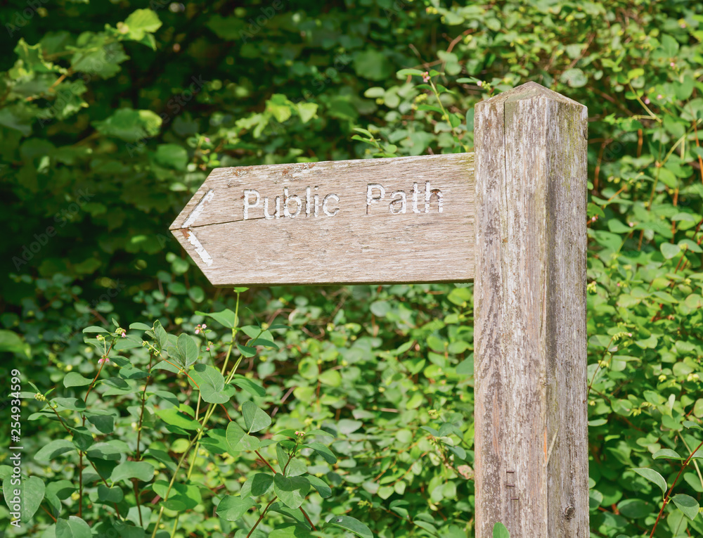 Weathered wooden sign post pointing to Public Path