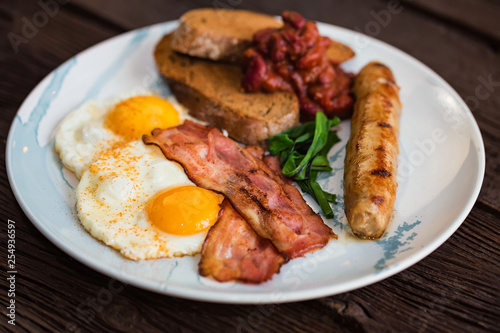 Typial breakfast with eggs, bacon and sausage on plate