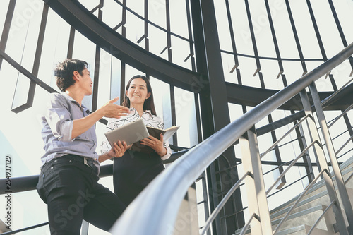 Two businessmen, men and women are talking about business plans. On the stairs in a modern building