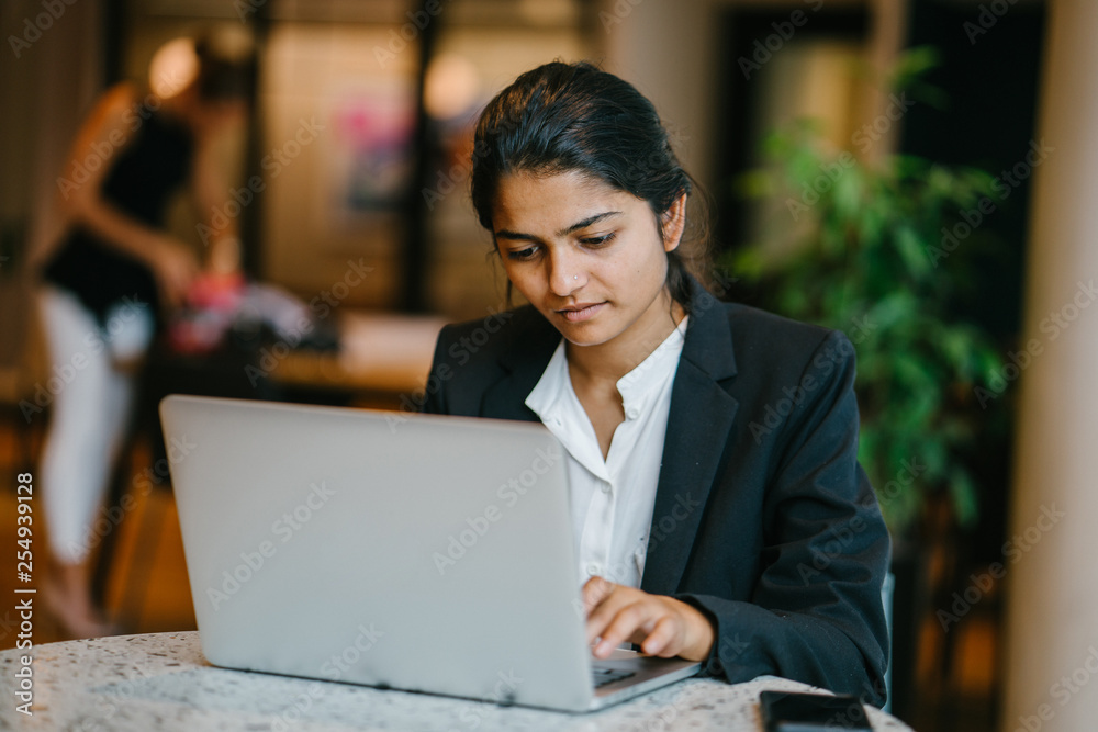 A wonderful Indian lady respecting a partner while in a talk. She is grinning before an associate while chipping away at a PC. A wonderful Indian lady respecting a partner while in a talk. She is grinning before an associate while chipping away at a PC.