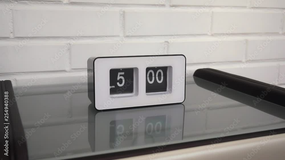Flip clock mechanism. 500 PM. Flip clock watch face. White brick wall